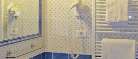 A bathroom with a sink, mirror, and towel rack.
