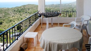 A balcony with a foosball table, a small table, and two chairs, overlooking a scenic landscape. - Vacation home Grecia by Interhome (Peñiscola)