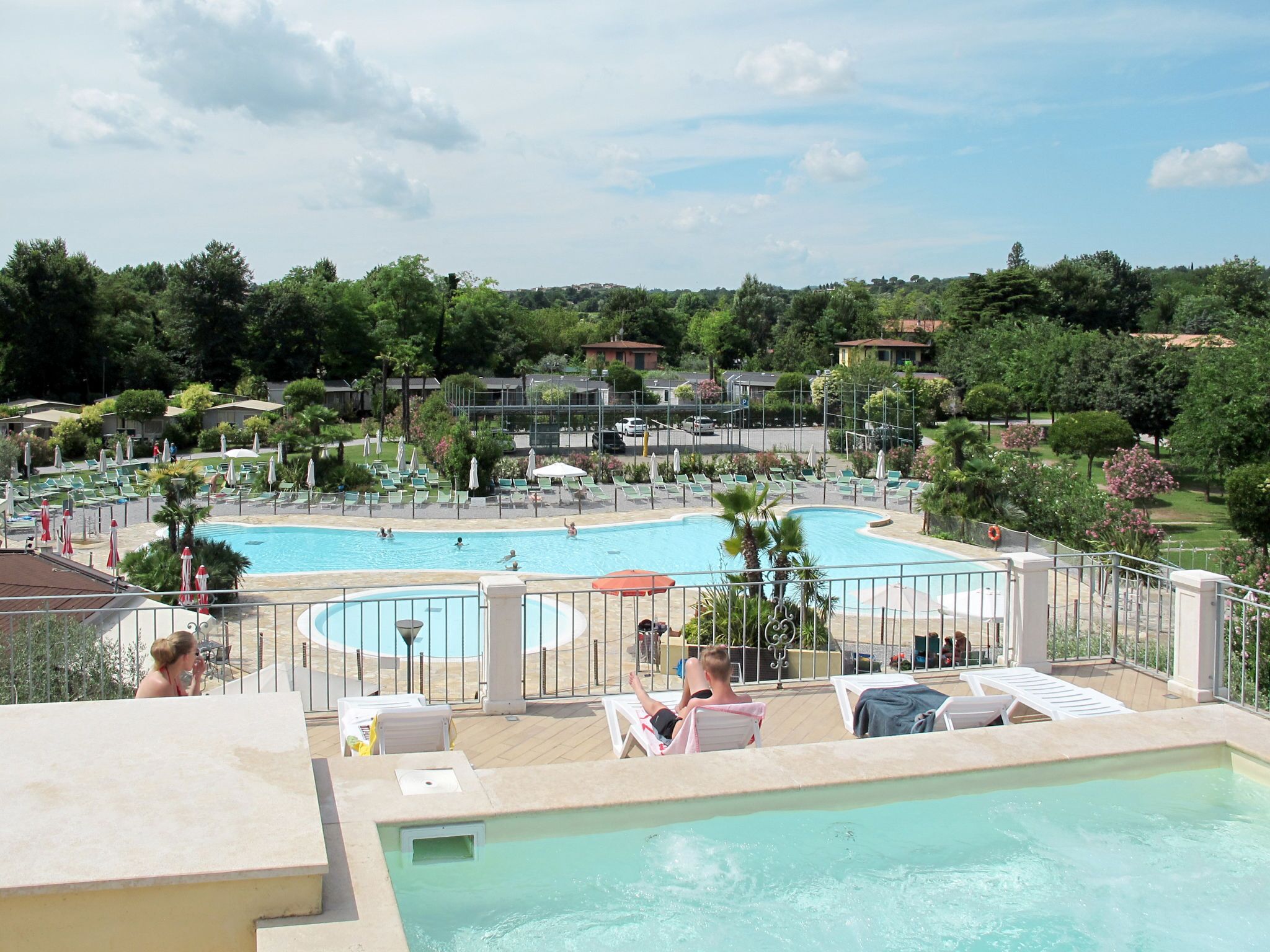 A pool area with multiple swimming pools, lounge chairs, and umbrellas.