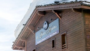 Un edificio de madera con un letrero que dice "Le Lodge Hemera", indicando que es un hotel con spa y servicios de belleza.