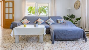 Une pièce comprenant un canapé, une petite table et une horloge murale.