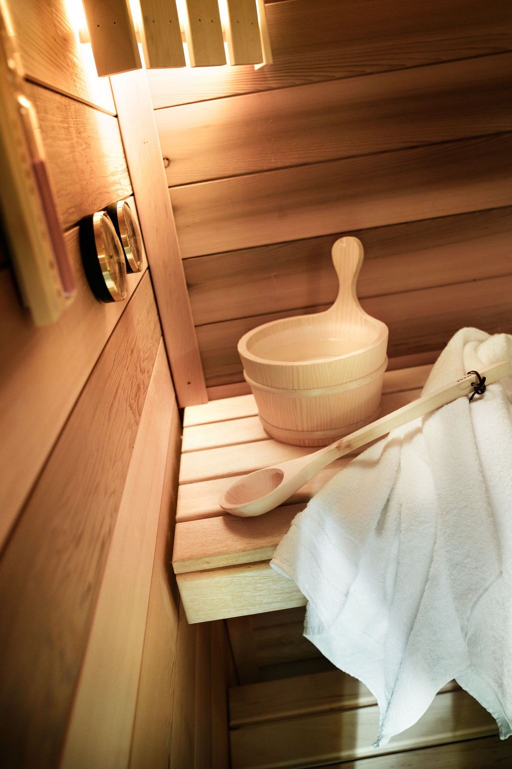 En sauna med træbænke, en træskål og en træske.