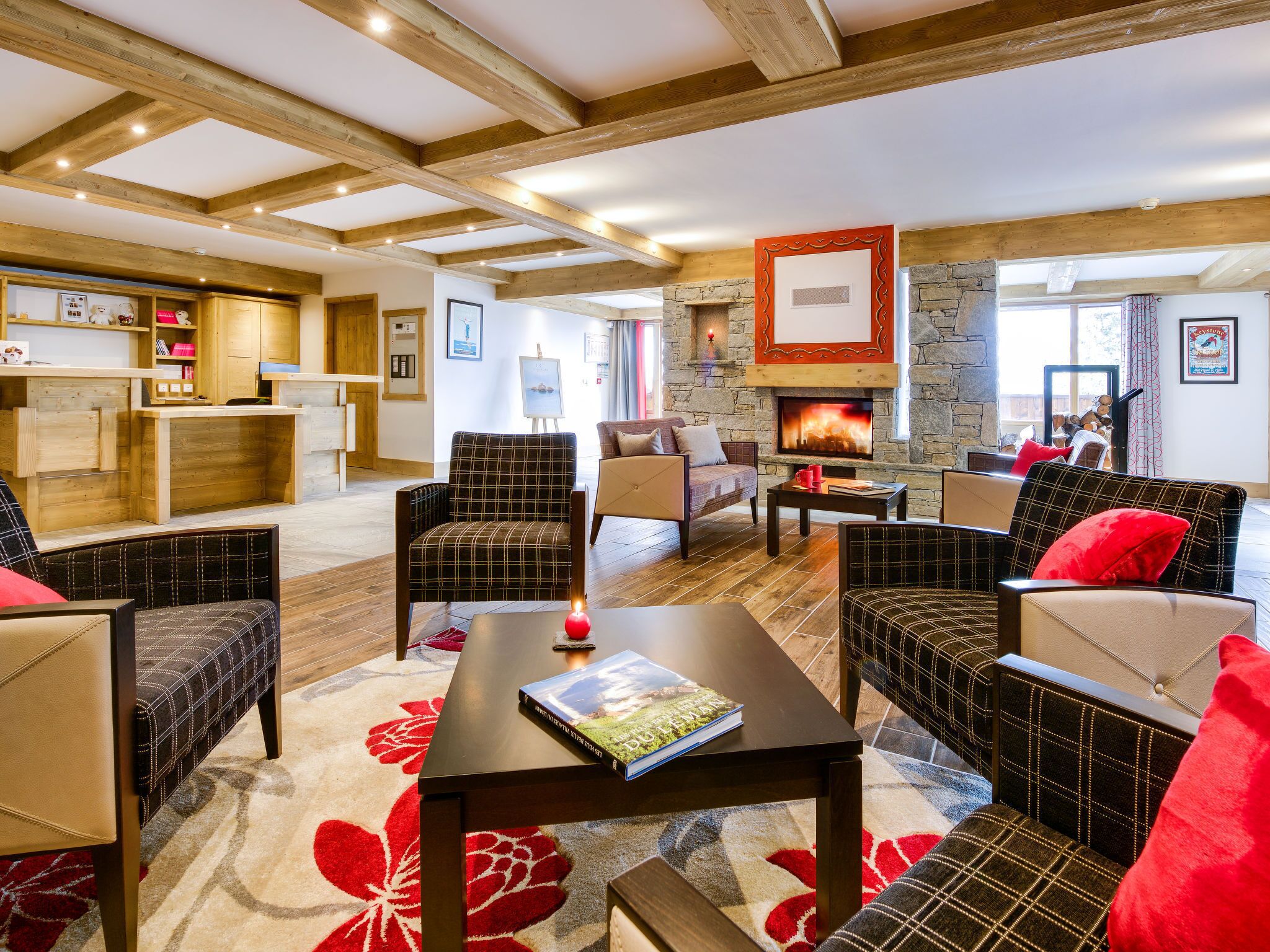 A spacious living area with a fireplace, wooden furniture, and a reception desk.