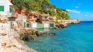 A coastal building with multiple rooms, some with balconies, overlooking a clear blue sea. - Vista Playa by Interhome (Llombards/C.Llombards/C.S'Almonia)