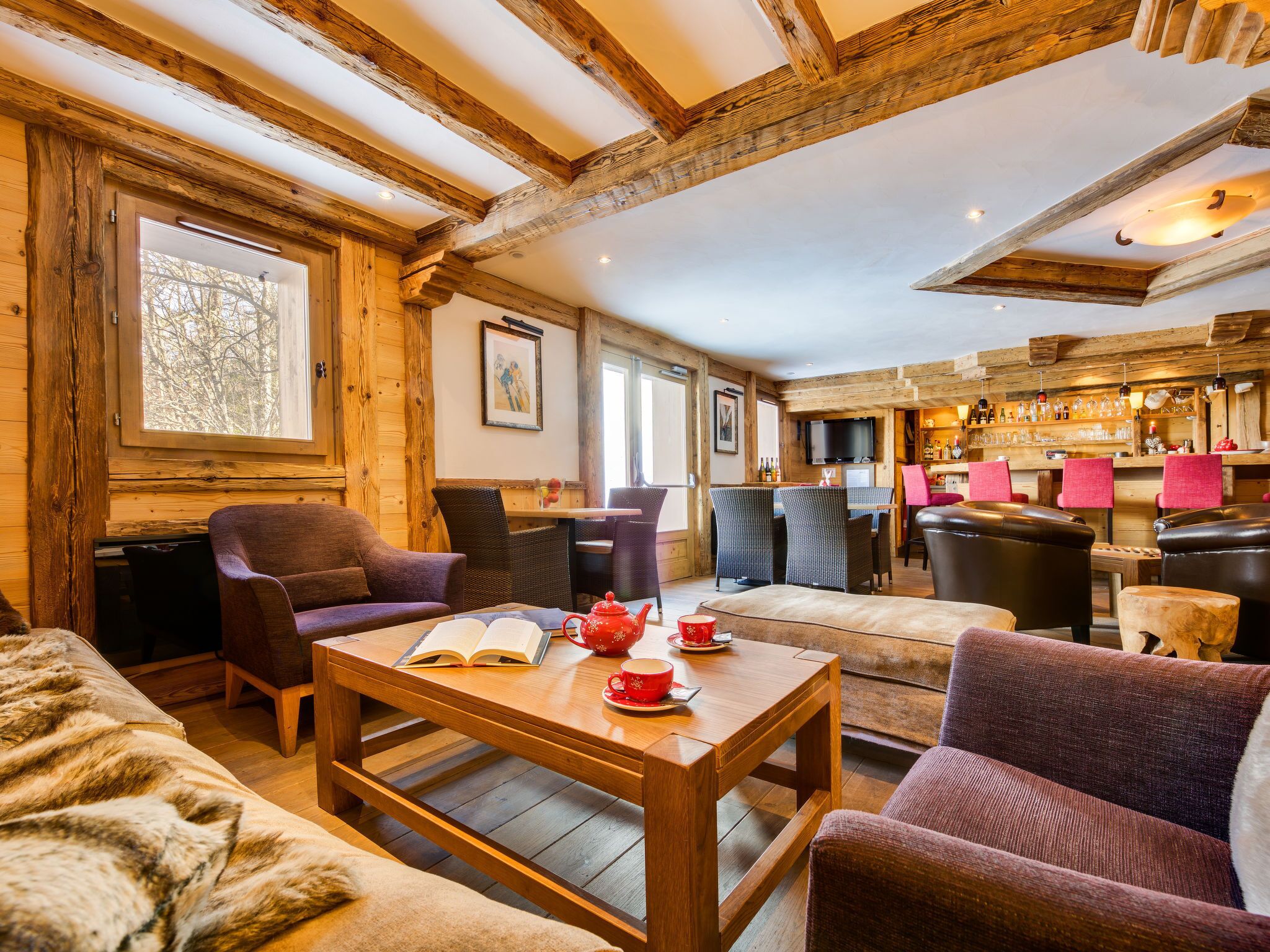 Una habitación acogedora con vigas de madera, una zona de bar y asientos.