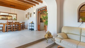 A spacious living area with a dining table, chairs, a sofa, and a decorative lamp. - Can Amagat by Interhome (Felanitx)