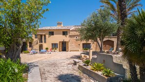 A Mediterranean-style villa with a courtyard, outdoor seating, and a mix of stone and stucco architecture. - Can Amagat by Interhome (Felanitx)