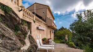 Un immeuble doté d’un balcon, d’un espace extérieur aménagé pour s’asseoir et d’un jardin.