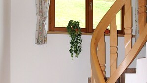 Una escalera con barandillas de madera y baldosas color beige.