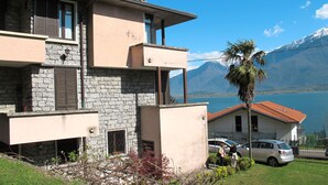 A two-story building with stone and plaster exterior walls, a balcony, and a view of a lake and mountains. - Salice Verde (GLA134) by Interhome (Gera Lario)