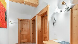A wooden interior with a tiled floor, a wooden desk with drawers, and a telephone on the wall. - Prieslern by Interhome (Bramberg am Wildkogel)