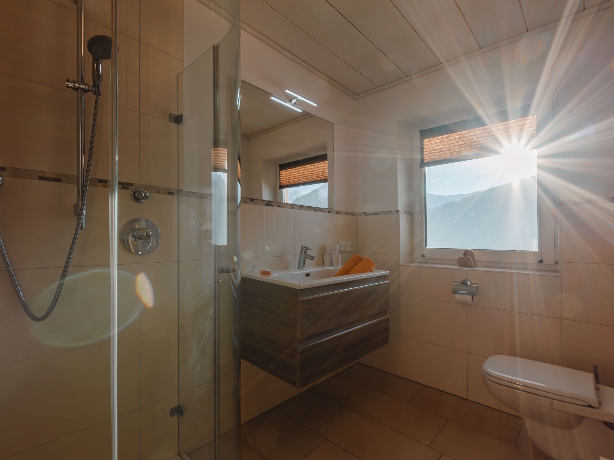 Un bagno moderno con doccia vetro, mobile lavabo con specchio e toilette.