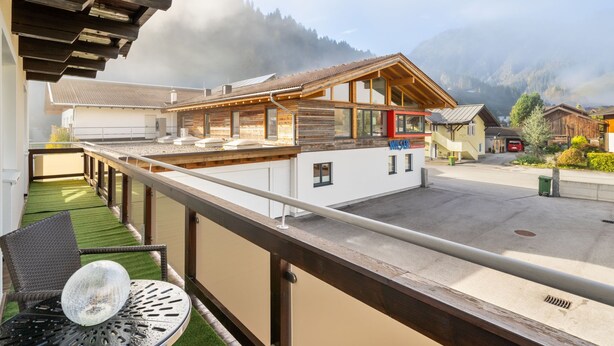 A modern hotel with a wooden facade, a rooftop terrace with a table and chairs, and a view of the surrounding mountains. - Weberbauer by Interhome (Mittersill)