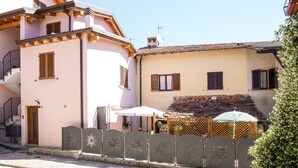 Un bâtiment à la façade rose, doté de balcons en bois et d’un toit recouvert de tuiles.