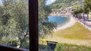 A coastal town with a beach, houses, and a mountainous backdrop. - Apartment Betti by Interhome (Domaso)