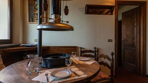 A dining table set with plates, cutlery, and a pitcher, with a hanging light fixture above. - Arte e Cucina by Interhome (Gravedona)