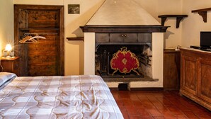 A bedroom with a bed, a wooden door, a fireplace, and a television. - Arte e Cucina by Interhome (Gravedona)
