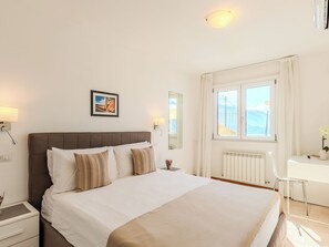 Une chambre d’hôtel avec un lit, une table de chevet, une lampe, une fenêtre et une vue sur l’extérieur.
