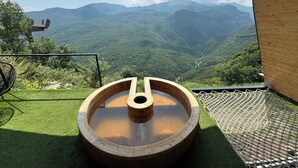 A hot tub on a balcony with a view of a mountainous landscape. - Lost in Sky (Yenokavan)