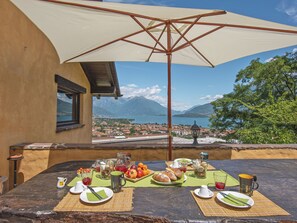 Une table dressée pour le petit-déjeuner, avec une vue imprenable sur un lac et des montagnes.