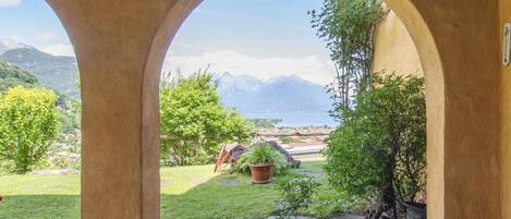 A view through an arched doorway overlooking a garden with a mountain backdrop.