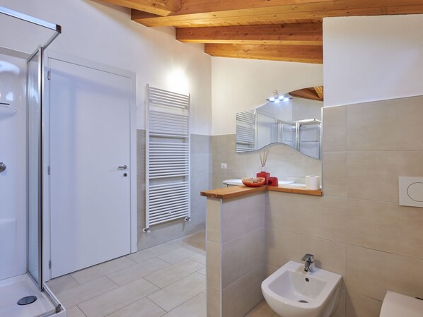 A modern bathroom with a shower, a sink, and a mirror.
