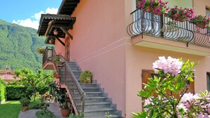 Ein zweistöckiges Gebäude mit einer Steinstufen-Treppe, die zu einem Balkon mit Blumenkästen führt.