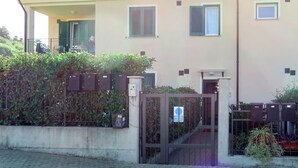 A two-story building with a gated entrance, a balcony, and a small window. - Apartment Roseto by Interhome (Cervo)