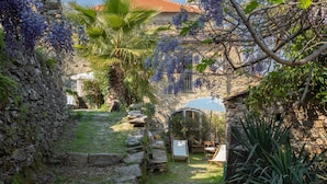 A stone pathway leading to a rustic building with a tiled roof. - Maria Luisa (DOL286) by Interhome (Dolcedo)