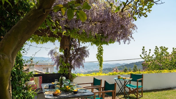 An outdoor dining area with a table set for two, surrounded by greenery and a view of the landscape. - Laura (DOL281) by Interhome (Dolcedo)