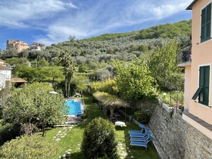 Una vila amb piscina, mur de pedra i vista a una collada.