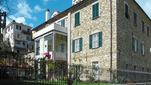 Un bâtiment en pierre doté de nombreuses fenêtres et d’un balcon.