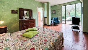 A bedroom with a bed, dresser, chair, and a TV stand. - Apartment NISSO by Interhome (Dolcedo)