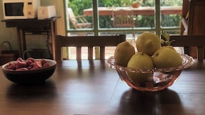 A kitchen with a microwave, a bowl of strawberries, and a bowl of lemons on the table. - Apartment NISSO by Interhome (Dolcedo)