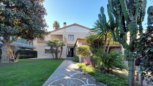 A residential property with a paved pathway leading to a house with a balcony. - Villa Gisi (Fiumicino)