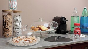 A kitchen counter with various items including a coffee maker, Nescafe Classic coffee, a water dispenser, and food items in glass containers. - Villa Gisi (Fiumicino)
