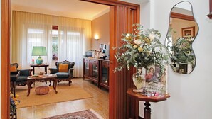 A living room with a sofa, armchair, coffee table, and a decorative mirror. - Villa Gisi (Fiumicino)