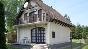 A two-story building with a balcony, a large window, and a small porch area. - Arvacska by Interhome (Balatonmariafurdo)