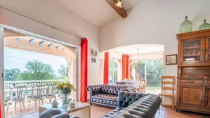 A spacious living area with a leather sofa, a dining table with chairs, and a wooden cabinet. - Bartavelle by Interhome (Sainte Maxime)