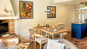 Een eethoek met een houten tafel, stoelen en een open haard.