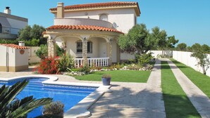 A Mediterranean-style villa with a swimming pool, a well-maintained lawn, and a stone pathway leading to the entrance. - Vacation home Silvia by Interhome (Miami Platja)