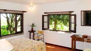 A room with a bed, a table, a chair, and two windows with open shutters. - Senhor do Socorro by Interhome (Caminha)