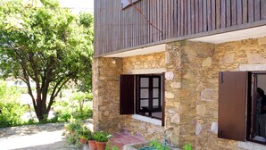A stone building with a balcony, potted plants, and a stone well. - Senhor do Socorro by Interhome (Caminha)