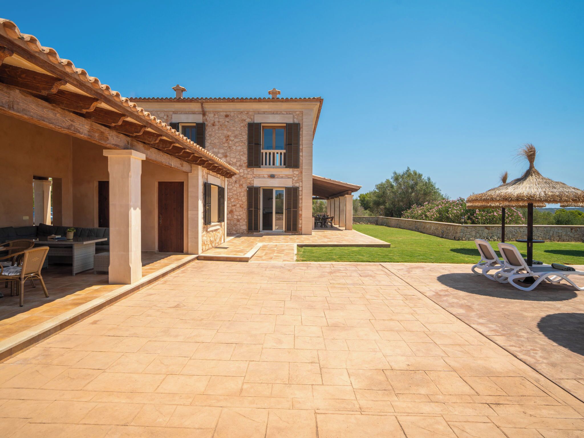 Une maison moderne dotée d’un patio, d’un espace salon extérieur et offrant une vue sur le paysage.