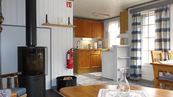 A cozy kitchen with wooden cabinets, a black stove, and a fire extinguisher.