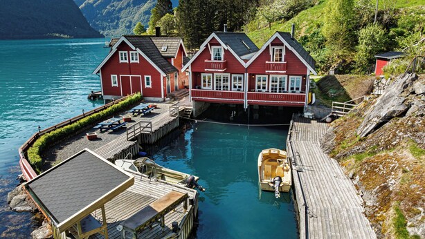 A wooden dock leading to a row of red houses by a lake. - Vardeheii by Interhome (Arnafjord)
