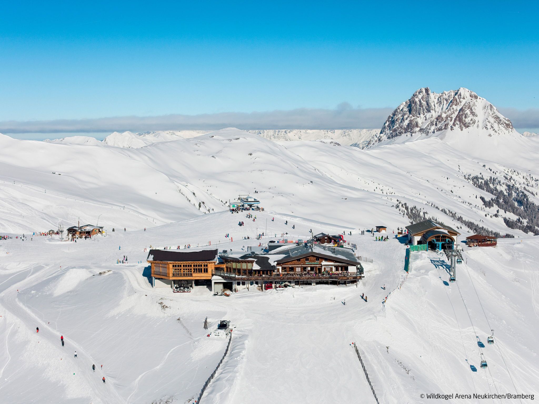 A ski resort with a large lodge, ski lifts, and a mountain backdrop.