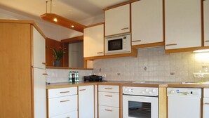 A kitchen with white cabinets, a microwave, an oven, and a dishwasher.