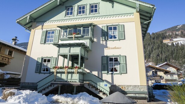 Een gebouw in traditionele Alpenstijl met een balkon en een trap die naar de ingang leidt, met een bord waarop de naam "Eternhaus" staat.
