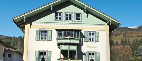 A traditional two-story building with a balcony, a staircase leading to the entrance, and a sign reading "Elternhaus".